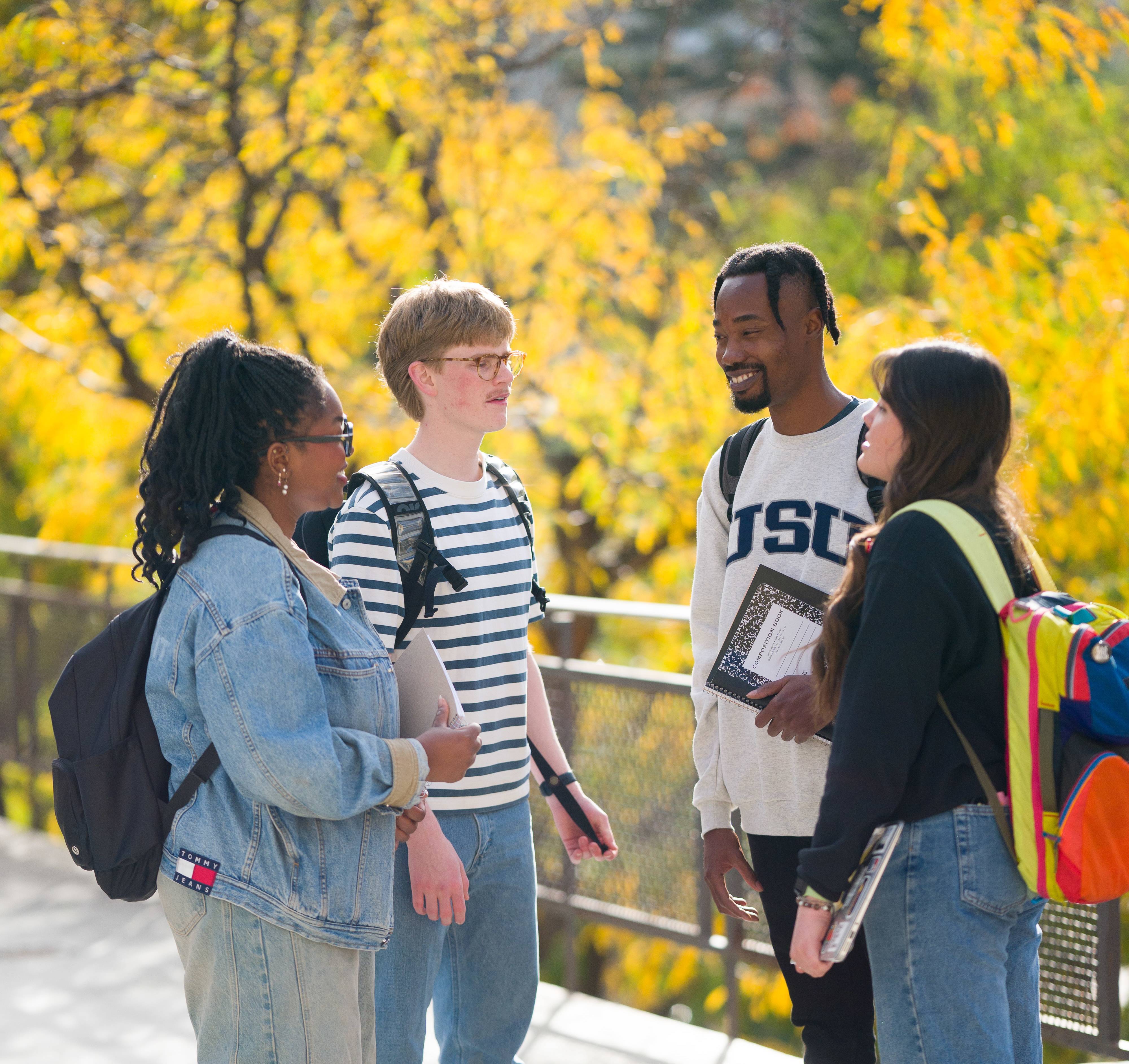 A group of students standing outsie and talking