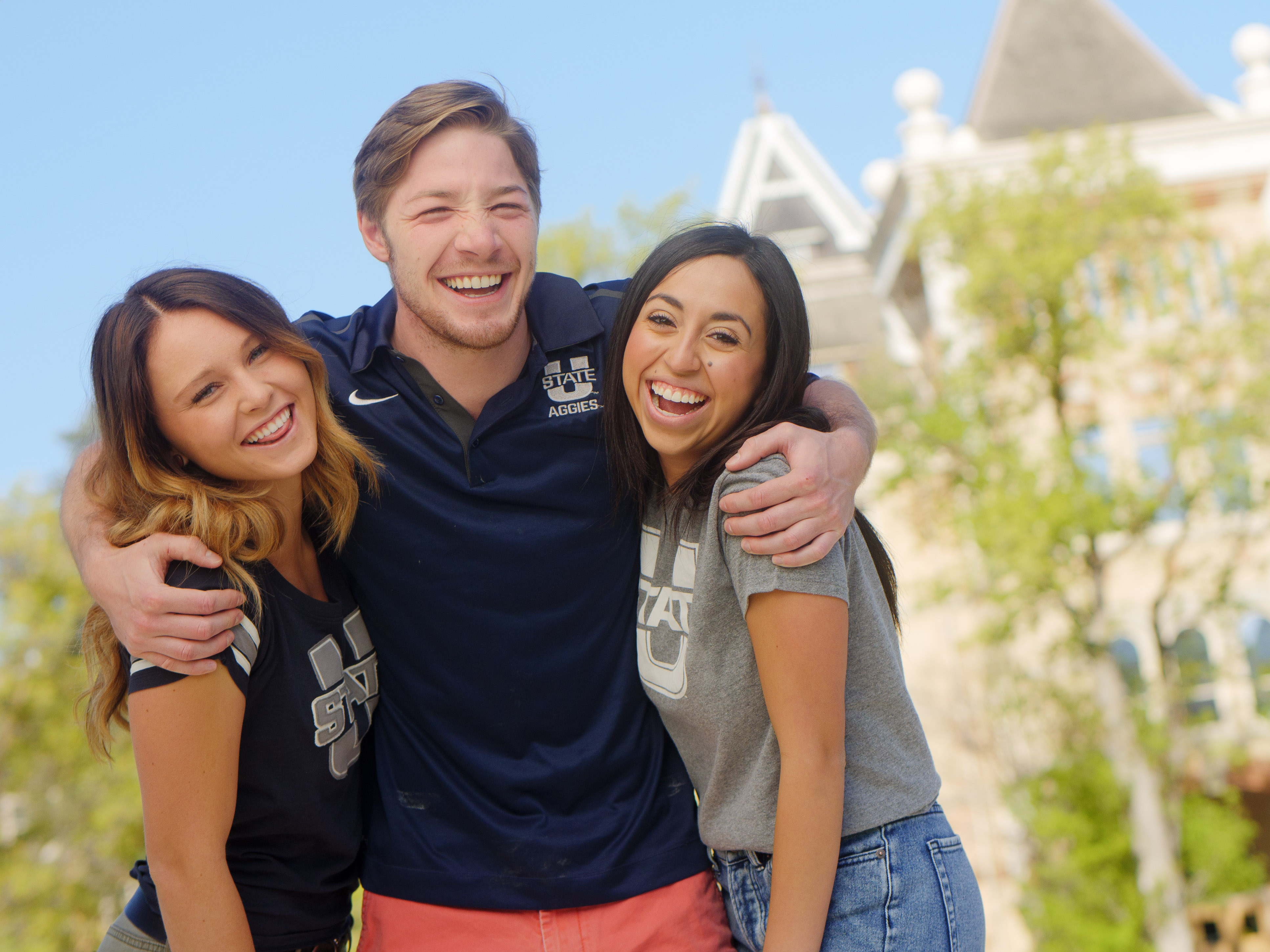 Three Utah State students infront of old main.